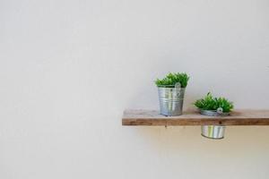 Wooden shelf on mortar wall with vase plant photo