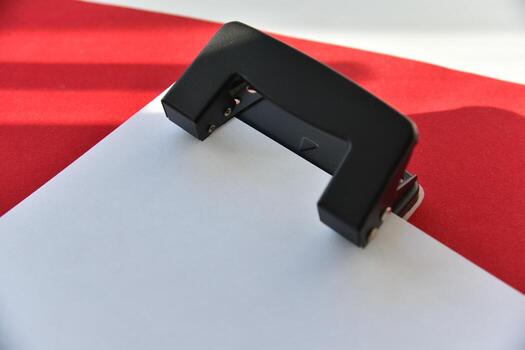 Pencils hole punch and notepad on a red background photo