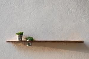 tablón de madera en la pared con planta de jarrón foto