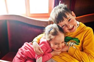 Brother and sister hugs. Funny smiling kids. photo