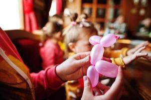 los niños en la fiesta de cumpleaños hacen animales con globos. foto