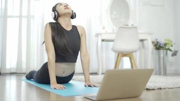 asiatiska kvinnor lär sig yoga online i videokonferenser, fitnessinstruktör, yoga online, videosamtal på laptop. video