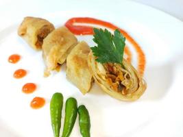 Lumpia is a typical Central Javanese Indonesian snack consisting of a mixture of young bamboo shoots, eggs, fresh vegetables, and meat or seafood, in a roll made of thin sheets of wheat flour photo