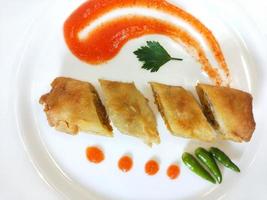 Lumpia is a typical Central Javanese Indonesian snack consisting of a mixture of young bamboo shoots, eggs, fresh vegetables, and meat or seafood, in a roll made of thin sheets of wheat flour photo