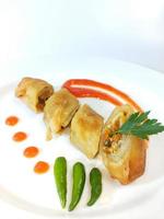 Lumpia is a typical Central Javanese Indonesian snack consisting of a mixture of young bamboo shoots, eggs, fresh vegetables, and meat or seafood, in a roll made of thin sheets of wheat flour photo