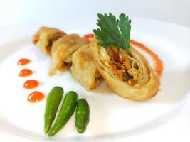 Lumpia is a typical Central Javanese Indonesian snack consisting of a mixture of young bamboo shoots, eggs, fresh vegetables, and meat or seafood, in a roll made of thin sheets of wheat flour photo