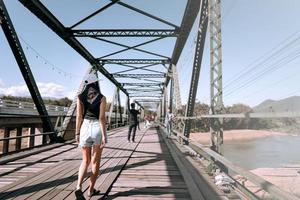 Traveller adult asian tan skin woman walking at Pai historical bridge. photo