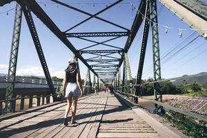 Traveller adult asian tan skin woman walking at Pai historical bridge. photo