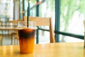 Café negro helado con taza de yuzu en la mesa foto