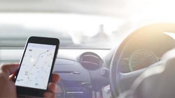 Hand using smartphone GPS navigation inside car