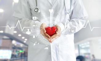 médico con forma de corazón rojo en la mano y conexión de red médica de icono con interfaz de pantalla virtual moderna, concepto de red de tecnología médica foto