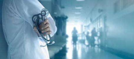 Doctor with stethoscope in hand on hospital background photo