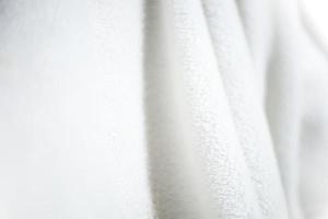 White shaggy blanket texture as background. Fluffy fake textile fur. photo