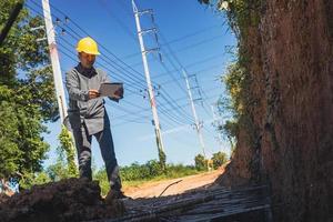 architect or civil engineer with hardhat on construction site checking schedule on tablet computer photo