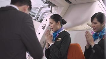 feliz azafata asiática parada en la puerta de entrada sonriendo y dando la bienvenida a los pasajeros al avión. trabajar en el extranjero o concepto de viaje para negocios de aerolíneas. video