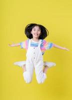 Full length image of Asian child posing on yellow background photo