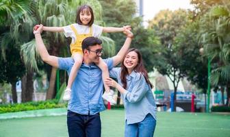 imagen de una joven familia asiática jugando juntos en el parque foto