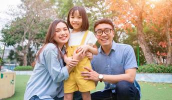 Image of young Asian family playing together at park photo