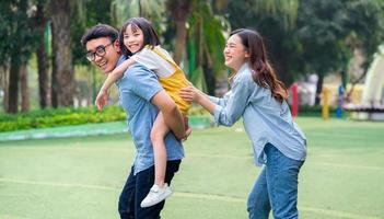 Image of young Asian family playing together at park photo
