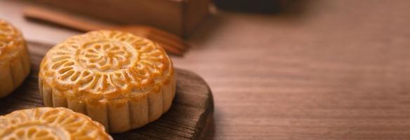 Round shaped moon cake Mooncake - Chinese style traditional pastry during Mid-Autumn Festival  Moon Festival on wooden background and tray, close up photo