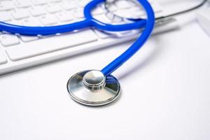 Medical Concept - Stethoscope on computer keyboard on white background. Physician long term care treatment. Close up, macro, copy space photo