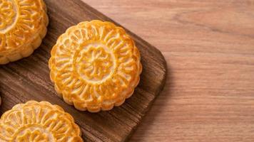 Round shaped moon cake Mooncake - Chinese style pastry during Mid-Autumn Festival  Moon Festival on wooden background and tray, top view, flat lay. photo