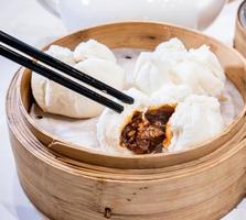 Delicious dim sum, famous cantonese food in asia - Fresh and hot Cha Siu Bao, BBQ pork bun in bamboo steamer in hong kong yumcha restaurant, close up photo