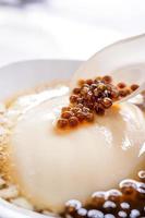 Popular Taiwan gourmet - Dessert of tapioca pearl ball bubble mixed bean curd tofu pudding douhua, dou hua in white bowl, close up, lifestyle photo