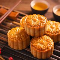 Moon cake Mooncake table setting - Round shaped Chinese traditional pastry with tea cups on wooden background, Mid-Autumn Festival concept, close up. photo