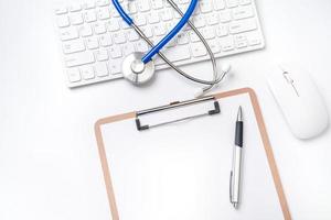 Medical Concept - Stethoscope on computer keyboard on white background. Physician long term care treatment concept. Top view, flat lay, copy space photo