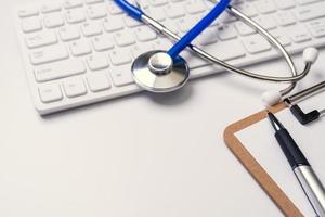 Medical Concept - Stethoscope on computer keyboard on white background. Physician long term care treatment. Close up, macro, copy space photo