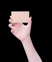 Young asia clean girl hand holding a blank kraft brown paper card template isolated on black background, clipping path, close up, mock up, cut out photo