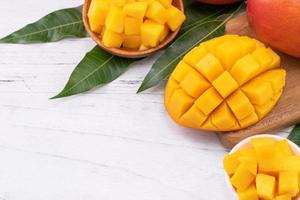 Fresh chopped mango on a tray and bright rustic wooden background. Tropical summer fruit design concept, close up, macro, copy space. photo