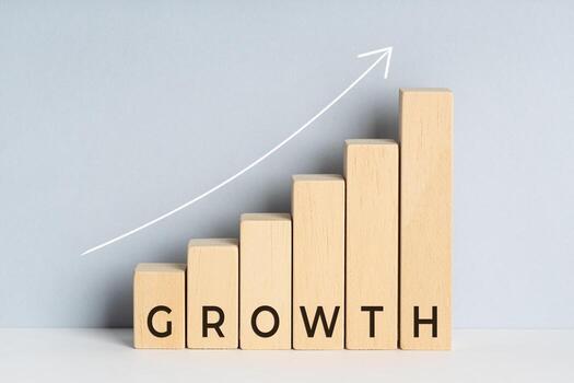 Growth concept. Wooden block bar chart graph with text and upward trend line drawn on background. Copy space photo