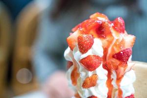 Strawberry sundae tower ice-cream with whip cream and strawberry sauce.