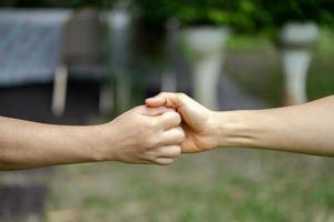 la mano se mantiene unida en la comunidad en el parque del jardín. foto