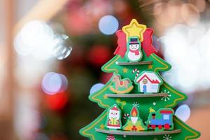 Christmas tree paper craft decoration on the wood table with blur big Christmas tree behide. photo