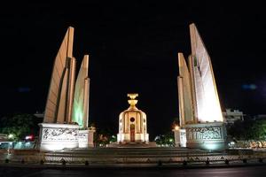 monumento a la democracia de tailandia en la noche con luz de coche de movimiento en la calle. foto