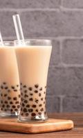 Popular Taiwan drink - Bubble milk tea with tapioca pearl ball in drinking glass and straw, wooden table gray brick background, close up, copy space photo