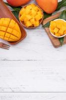 Fresh chopped mango on a tray and bright rustic wooden background. Tropical summer fruit design concept, close up, macro, copy space.