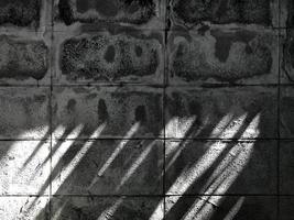 old and dirty concrete fence with sunlight and shadow on it. photo