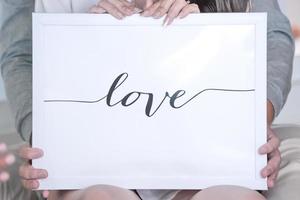 LOVE letter in the white frame and background, Hold by bride and groom behind. photo