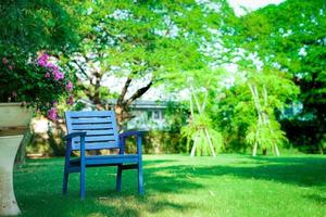 una silla azul de madera sola en el jardín. sentirse solo, pero relajante y retiro foto