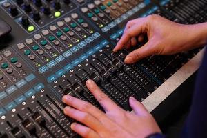 Close up to hand of DJ on the sound bar machine for Music concert. photo