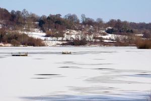 Snow laying on the ice at Weir Wood Reservoir photo