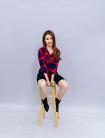 The young woman sitting on the chair smiled happily with the photo shoot. Concept