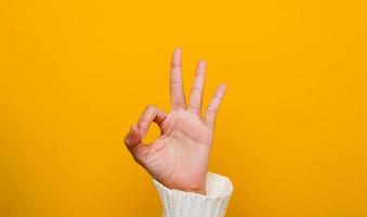 imagen de manos mostrando un gesto correcto en un fondo amarillo foto