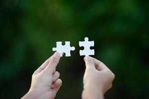 Hands and white jigsaw puzzles Close-up image and integration Business concept and unity photo