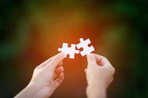 Hands and white jigsaw puzzles Close-up image and integration Business concept and unity photo