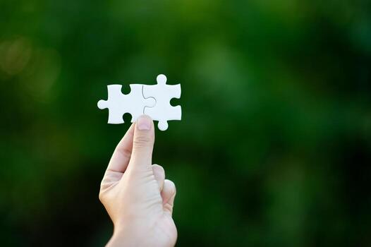 Hands and white jigsaw puzzles Close-up image and integration Business concept and unity photo